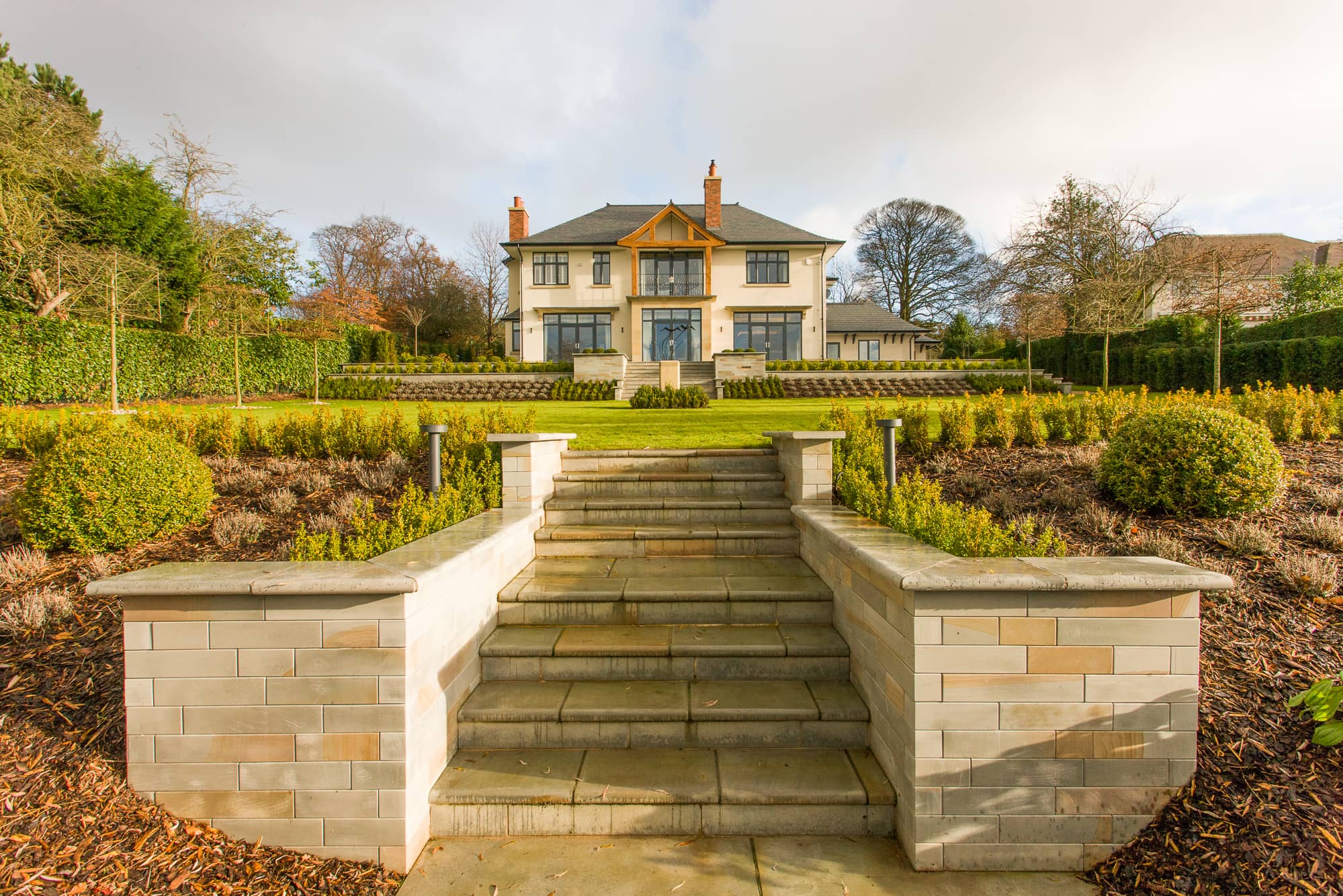 a large house with a stone staircase leading up to it.